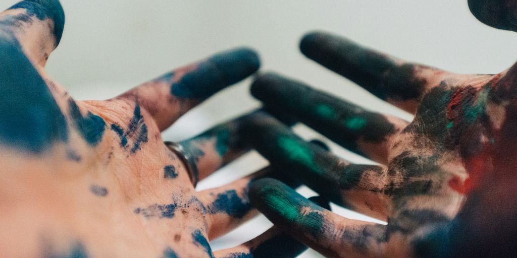 person hand with green and blue paint